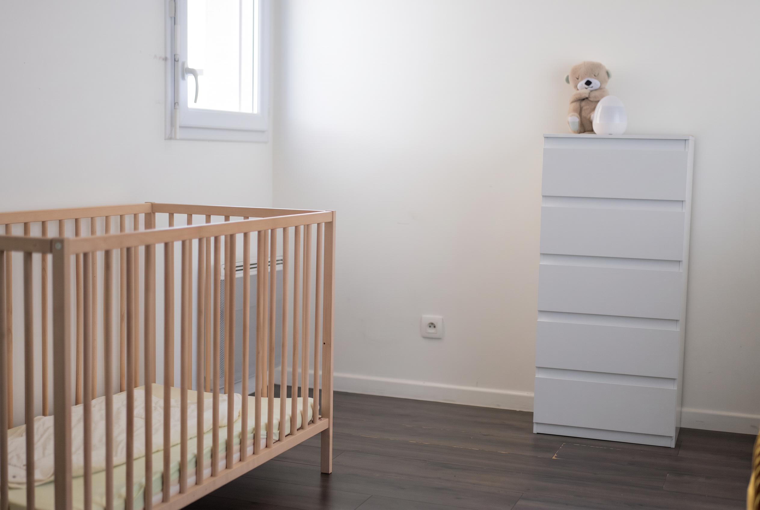 La chambre calme avec le lit à barreaux pour la sieste des tout-petits