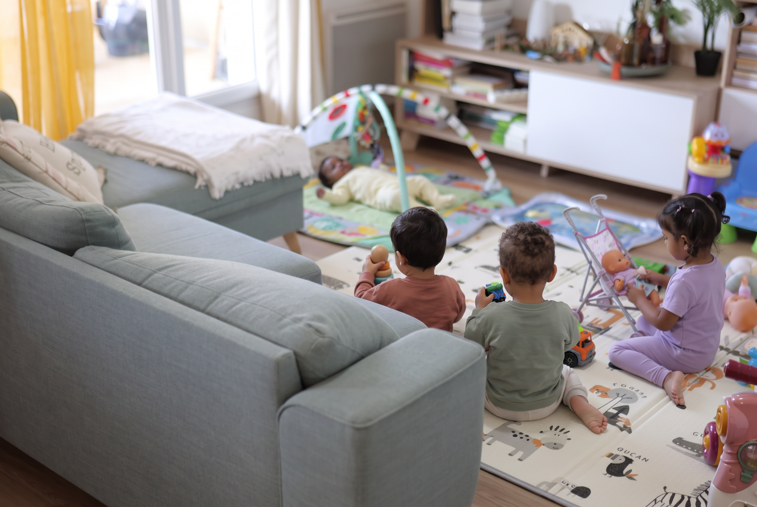 Le salon de Corinne à Argenteuil, avec quatre enfants jouant sur les tapis d'éveil